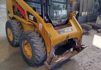 Smykový nakladač CAT 226B2 před opravou – vytlučené uložení rychloupínače